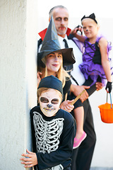 Image showing Portrait, halloween and a family in costume for trick or treat tradition or holiday celebration. Mother, father and children at a door in fantasy clothes for dress up on allhallows eve together