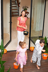 Image showing Family house, halloween and children running with candy for fun adventure or vacation tradition. Happy, love and mom watching kids in costume with candy, laugh and energy in costume for holiday prank