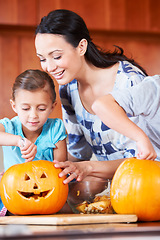 Image showing Halloween, pumpkin and mother with child in the kitchen for holiday celebration at home. Creative, smile and happy mom with girl kid bonding and carving vegetable for decoration or tradition at house