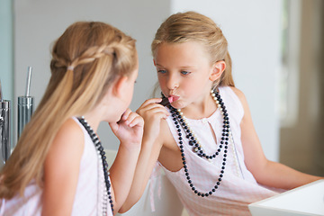 Image showing Child, mirror and smile for makeup, lipstick and playing in bathroom, application and fun at home. Female person, girl and reflection of beauty, cosmetics and skincare or ready, routine and grooming