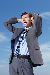 Image showing Stress, blue sky and a business man screaming outdoor in frustration from tax, debt or financial crisis. Burnout, bankrupt and economy with an unemployed young person shouting in a corporate suit