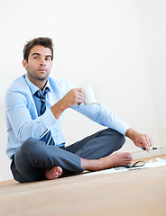 Image showing Thinking, coffee and business man on floor in office for brainstorming, solution and problem solving. Corporate, professional and entrepreneur with ideas for company, career and job in workplace