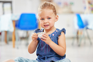 Image showing Portrait, kid or little girl with tea cup in kindergarten, daycare or classroom for playing. Youth, happy and smile for fun activity with delicious, fresh and beverage for development of motor skills