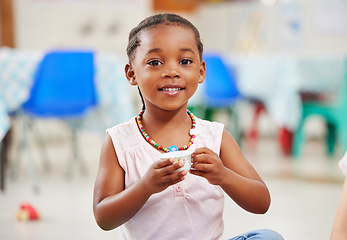 Image showing Portrait, little girl and cup with smile in kindergarten, daycare or classroom for playing. African kid, youth and happy for fun with delicious, fresh and beverage for development of motor skills