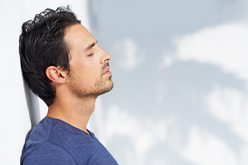 Image showing Thinking, calm and man profile by a white wall outdoor in the sun with freedom and ideas. Relax, peace and male person with mockup and summer with vitamin D, leaning and contemplating with outfit