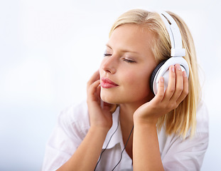 Image showing Woman, relax and headphones for music on a white background for audio streaming service and mental health podcast. Student or calm person listening to music with dream, sleeping or peace in studio