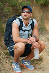 Image showing Fitness, man and thinking of nature hiking with water, backpack and energy drink for workout, training and exercise. Hiker, person and planning mountains trail for health, wellness and summer sports
