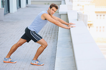 Image showing Man, portrait and stretching body on balcony in city for fitness, workout or outdoor exercise. Active male person in warm up, stretch or preparation for training or run in health and wellness outside