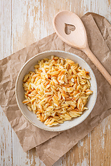 Image showing Cooked italian pasta, risoni, orzo in a bowl on wooden table