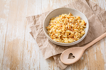 Image showing Cooked italian pasta, risoni, orzo in a bowl on wooden table