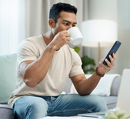 Image showing Man, phone and reading with coffee on sofa in home for taste of hot beverage. Asian person, technology and mobile app for message, internet or social media by cellular with drink to relax living room