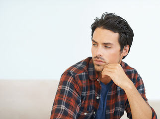 Image showing Man, thinking and serious on sofa for question, idea and contemplating in living room of apartment or home. Person, face and mental health or thoughtful on couch in lounge for anxiety on weekend