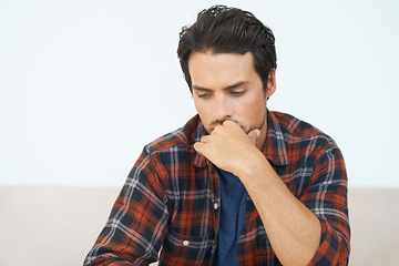 Image showing Man, thinking and serious or hands for question, idea and contemplating in living room of apartment or home. Person, face and mental health or thoughtful on couch in lounge for anxiety or nervous