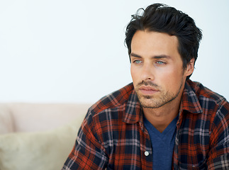 Image showing Man, thinking and serious on sofa for idea, question and contemplating in living room of apartment or home. Person, face and thoughtful or calm by couch in lounge for chill, rest and shirt on weekend