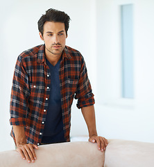 Image showing Man, thinking and serious by sofa for idea, question and contemplating in living room of apartment or home. Person, face and thoughtful or calm by couch in lounge for chill, rest and shirt on weekend