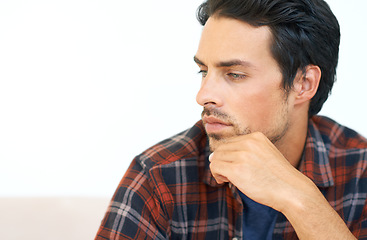 Image showing Man, thinking and serious or hands for question, idea and contemplating in living room of apartment or home. Person, face and mental health or thoughtful on couch in lounge for anxiety on weekend
