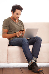 Image showing Credit card, laptop and man on sofa for online shopping, e commerce and digital payment on fintech software. Person on couch, typing on computer and internet banking for financial investment or sale