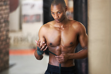 Image showing Fighting, gym and black man wrapping hands with fitness, power and training challenge. Strong body, muscle workout and boxer in gym, athlete with confidence and getting ready for boxing competition.