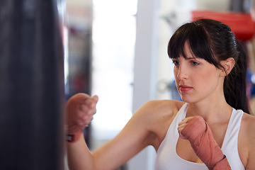 Image showing Boxing, gloves and woman with bag, training and fitness for power, wellness and workout challenge. Strong body, muscle and girl boxer in gym, athlete with confidence and pride for competition fight