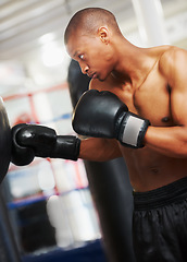 Image showing Boxing, gloves and black man training in gym with fitness, power and workout challenge. Strong body, muscle and boxer in club, athlete fighting with bag for exercise and confidence in competition.