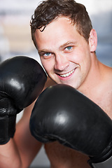 Image showing Boxing, gloves and portrait of man with smile for fitness, power and training challenge in gym. Strong body, muscle and confidence, happy boxer or athlete with fist up and competition fight champion.
