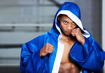 Image showing Black man, boxer and champion in robe at gym getting ready for fight, challenge or sports competition. Serious African male person or boxing fighter with fists in preparation for MMA match or game