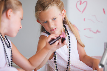 Image showing Little girl, lipstick and heart on mirror in bathroom for drawing, fun and picture with bad behavior. Young, child and determined expression for writing with cosmetics for trouble, mess or problem