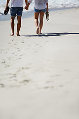 Image showing Love, holding hands and legs of couple on beach for date, outdoor bonding and tropical holiday. Romance, man and woman from back, walk and relax on vacation together with travel, care and adventure.