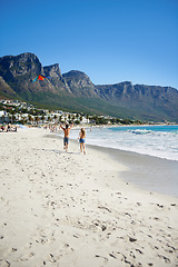 Image showing Love, kite and couple on beach, running on date for outdoor bonding and tropical holiday. Romance, man and woman at sea, fun and relax on ocean vacation together with travel, care and play adventure.