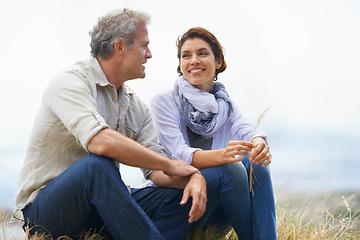 Image showing Couple, face and happy outdoor with relax, communication and peace for bonding, relationship or holiday. Mature, man and woman with smile, sitting and break in nature with travel, vacation and trust