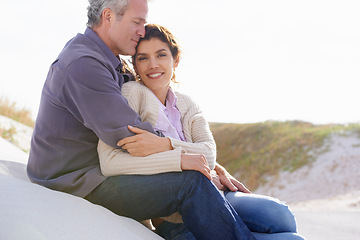 Image showing Couple, face and smile outdoor with hug for romance, love and relationship on beach with relaxing. Mature, man and woman or embrace with happy, peace and comfort for bonding, honeymoon and support