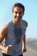 Image showing Happy man, portrait and running on road in fitness for exercise, cardio or outdoor training. Active male person smile with earphones for run on street or sidewalk in sweat for health and wellness