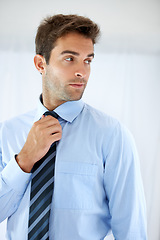 Image showing Job opportunity, tie and a business person getting ready for work in studio on a white background. Corporate, company and dressing with a young man adjusting his outfit for a professional career