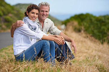 Image showing Couple, face and happy in nature with relax, communication and peace for bonding, relationship or roadtrip. Mature, man and woman with smile, sitting and break outdoor with travel, vacation and trust