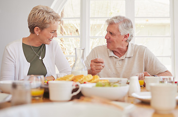 Image showing Breakfast, talking and lunch with senior couple, eating and happy together in a home. Love, support and care on a dining room with a smile and food with bonding in the morning with fruit in house
