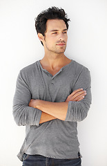 Image showing Crossed arms, fashion and young man by a white wall with casual, cool and trendy outfit. Serious, confidence and handsome male model from Canada standing and posing with edgy style for aesthetic.