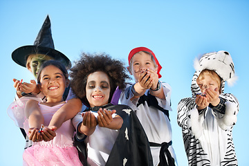 Image showing Children, group and hands in halloween costume for sweet candy asking, trick or treat for fantasy. Friends, smile and dress up as witch or pirate for holiday fun, kid development on sky background