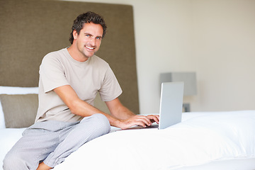 Image showing Portrait, man in bedroom and laptop to work from home, typing and sitting in bed for freelance job. Technology, Entrepreneur and remote worker for online job, company and marketing projects
