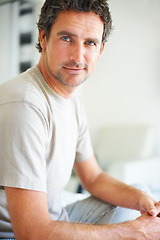 Image showing Portrait, relax and a mature man in the bedroom of his home to relax on a morning of the weekend. Face, wellness and happy with a confident person in casual pajamas sitting on a bed in his apartment