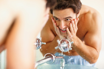 Image showing Man, washing and face with water in bathroom for clean, hygiene or germs in morning. Happy person, hands and soap for skincare, routine or dermatology in smile in home with reflection, fresh or care