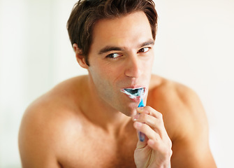 Image showing Bathroom, brushing teeth and man with dental hygiene, wellness and grooming routine for fresh breath. Person, home or guy with toothbrush, cleaning his mouth and morning with oral health or self care