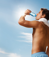 Image showing Man, drinking water and bottle with towel for workout, health body and fitness and vacation. Model, thirsty and natural glow with h2o drink for hydration and post cardio exercise by sky background