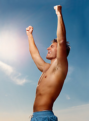 Image showing Winner, hands raised and a shirtless man on a blue sky with flare for fresh air in summer during vacation. Health, fitness and victory with the body of a confident young person outdoor for wellness