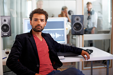 Image showing Portrait, media and a man producer in a recording studio mixing audio with a sound desk. Computer, tech or music with a serious young DJ or engineer creating a track for production or entertainment