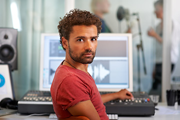 Image showing Portrait, music and a man producer in a recording studio mixing audio with a sound desk. Computer, tech or media with a serious young DJ or engineer creating art for production or entertainment