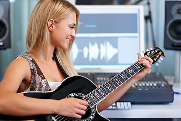Image showing Woman, guitar and computer in recording studio for music with smile, ideas and creativity for art, album or song. Musician, artist and instrument with pc for sound, audio and happy for entertainment