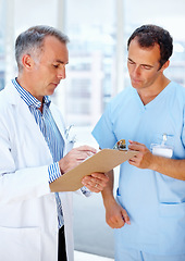 Image showing Healthcare, doctor and nurse with a clipboard, conversation and communication with test results, sign and wellness. Staff, medical and professional with documents, career and talking with physician
