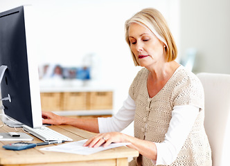 Image showing Mature woman at desk with computer, documents and administration for business accounting. Report, review and senior businesswoman reading invoice paperwork for finance, budget and office management.