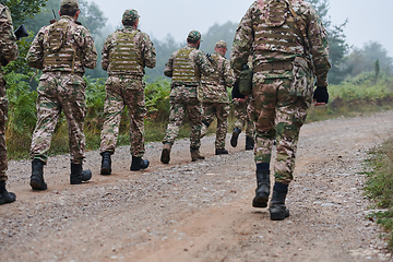 Image showing An elite military unit, led by a major, confidently parades through dense forest, showcasing precision, discipline, and readiness for high-risk operations