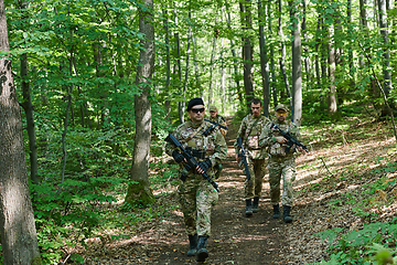 Image showing A specialized military antiterrorist unit conducts a covert operation in dense, hazardous woodland, demonstrating precision, discipline, and strategic readiness